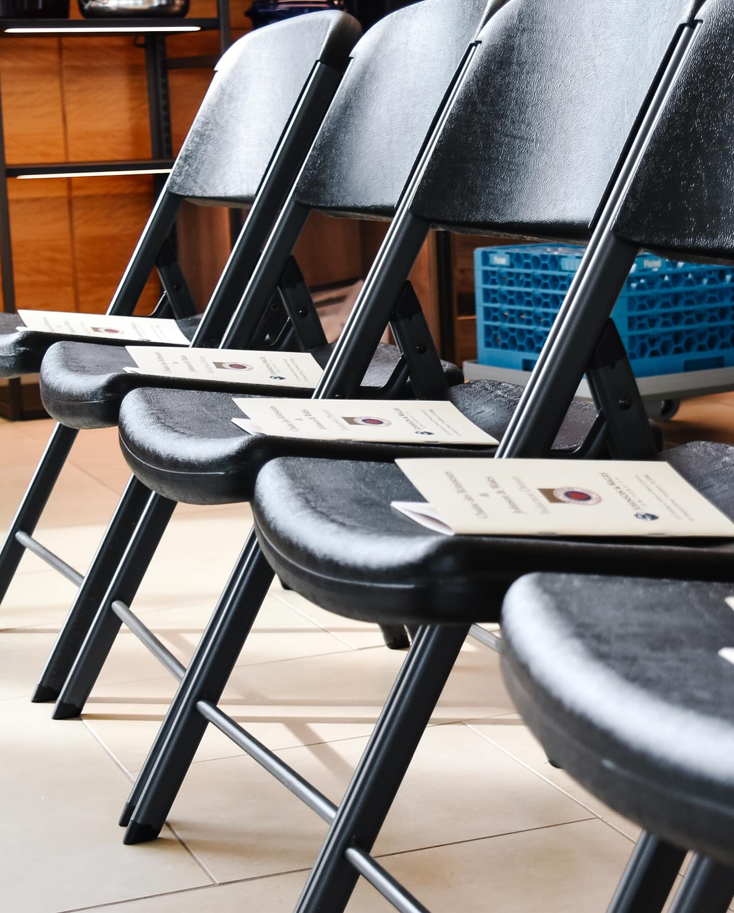 Professional event setup with printed programs on chairs showcasing OptiPrint's event materials and marketing collateral services